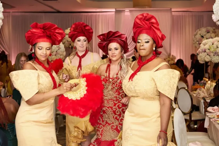 Friends in gold gowns and red geles celebrating with the bride