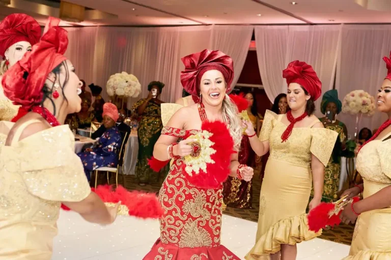 Bride in red and gold dancing with friends in gold gowns and red geles