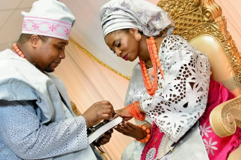 Groom placing a ring on the bride's finger at a Yoruba traditional engagement